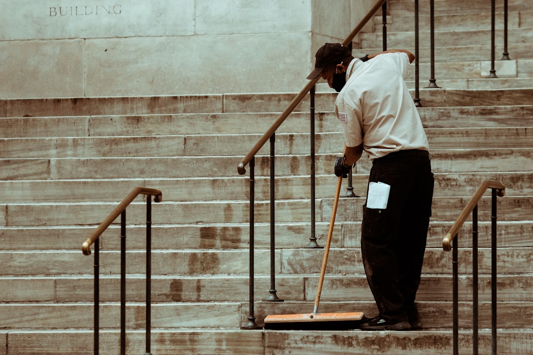 man-in-white-dress-shirt-and-black-pants-standing-on-brown-wooden-ladder-4ntnr8wtwcg